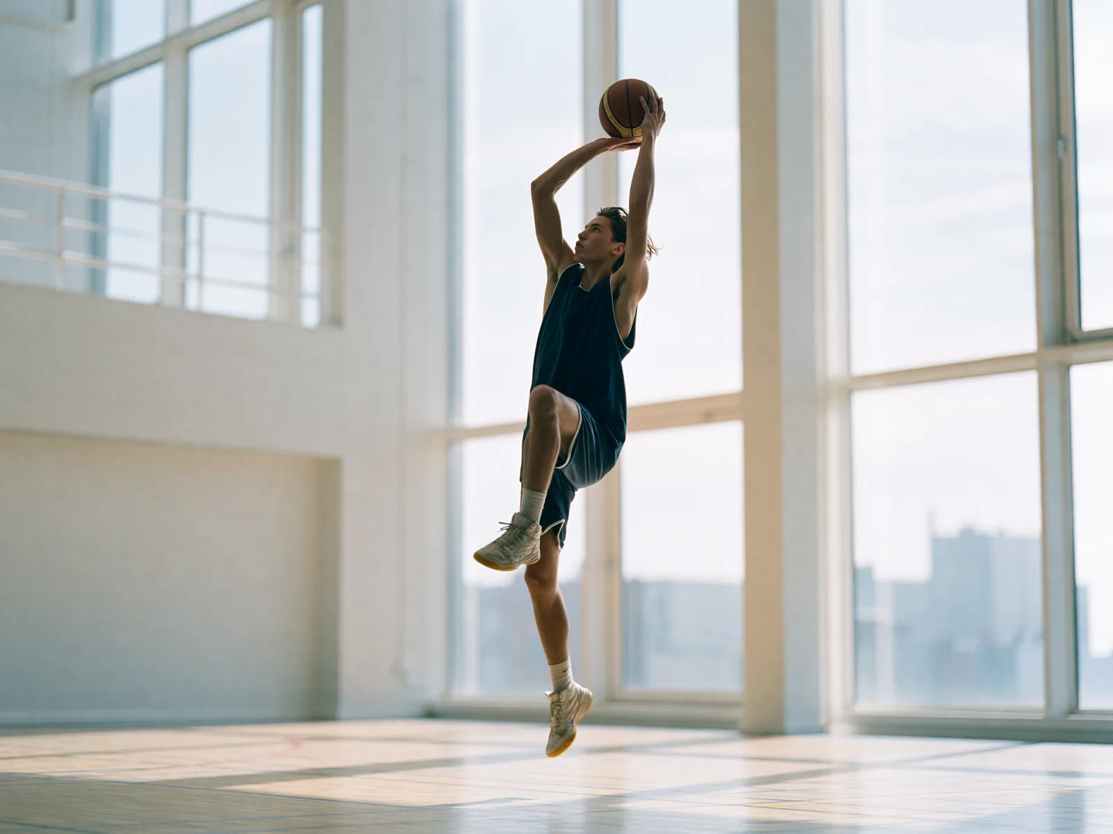 Basketteur en suspension dans une salle lumineuse